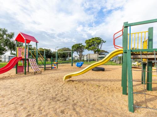 a playground with a slide in the sand at NRMA Portland Bay Holiday Park in Portland