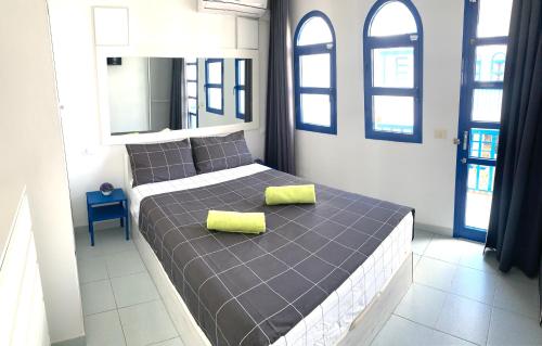 a bedroom with a bed with two yellow pillows on it at Bungalow Helena in Maspalomas
