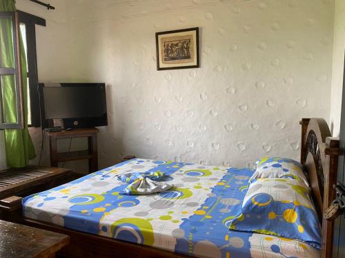 una camera con un letto e un piumone blu e bianco di CASA CAMPESTRE LA CAMPIÑA LA VICTORIA Valle del Cauca ESPACIO COMPLETO-desayuno a pareja a Matazarza