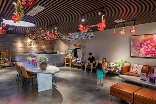 a woman walking through a room with a table at The Glomad Danang Hotel in Danang