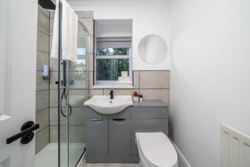 a bathroom with a sink and a toilet and a shower at Skyvillion - COZY House in Rochester, Kent- 3 Bed with Garden, WiFi & Parking in Rochester