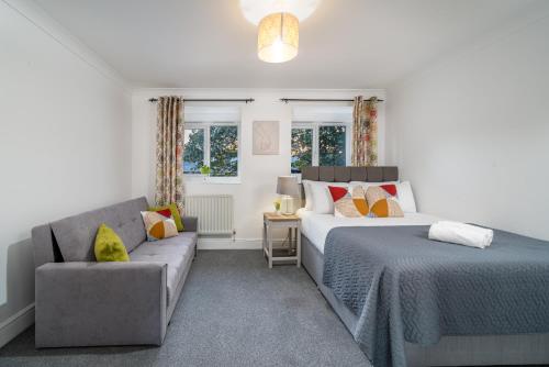 a bedroom with two beds and a couch at Skyvillion - COZY House in Rochester, Kent- 3 Bed with Garden, WiFi & Parking in Rochester