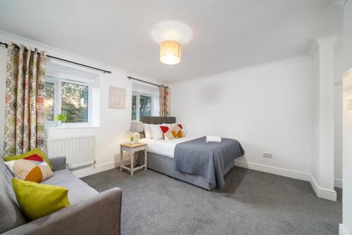 a bedroom with a bed and a couch at COZY 3 Bed House With Garden & Parking in Rochester, Kent Mins to Train Station, WiFi in Rochester
