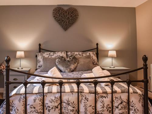 a bedroom with a bed with a heart on the wall at Daisys Dairy in Bishops Lydeard