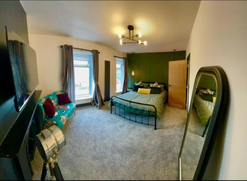 a bedroom with a bed and a couch in a room at THE SOUTH VALLEY HOME in Neath