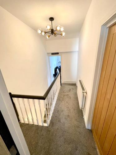 a hallway with a staircase with a ceiling fan at THE SOUTH VALLEY HOME in Neath