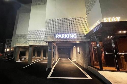 a parking lot outside of a building at night at The Van Stay in Busan