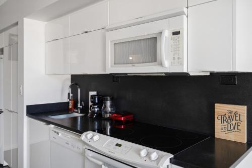 a kitchen with white cabinets and a black counter top at Family oriented Downtown Toronto 2BDRM Condo with Parking & office space in Toronto