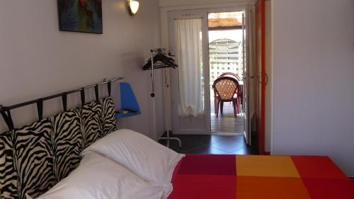 - une chambre avec un lit et une couverture colorée dans l'établissement Suite Harlequin, à Cournonterral