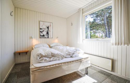 a bed in a room with a window at Awesome Home In Ebeltoft With 4 Bedrooms, Sauna And Wifi in Ebeltoft