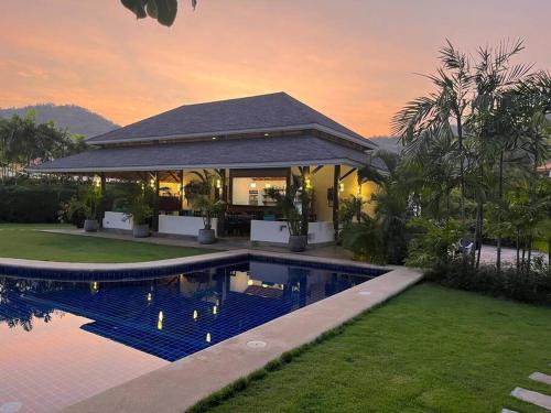 a house with a swimming pool in front of a house at Villa “Mango” in Villa Vista, Hua Hin in Khao Tao
