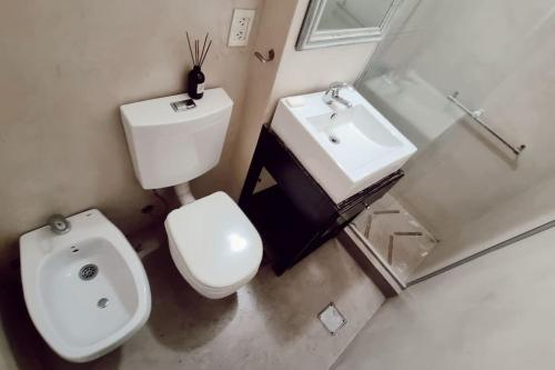 a white bathroom with a toilet and a sink at Studio en Las Cañitas in Buenos Aires