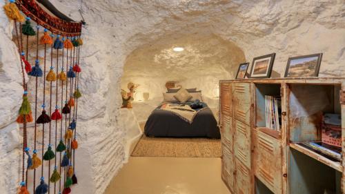 a bedroom in a cave with a bed in it at Daybreak Dugout Luxury Underground House in White Cliffs