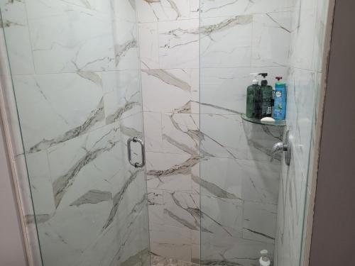 a bathroom with a shower with white marble at Relax place in Brampton