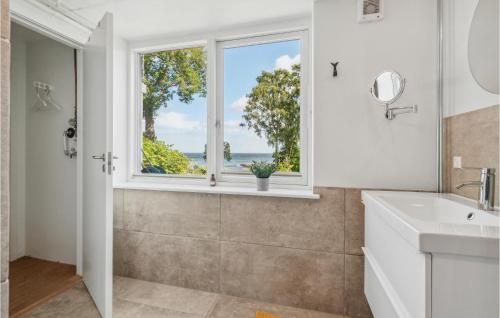 a bathroom with a sink and a window at Amazing Apartment In Svaneke With Kitchen in Svaneke