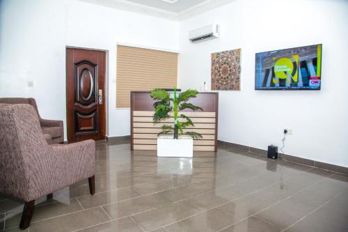 una sala de espera con una maceta en la pared en APARTMENT 437 BY BELMONT, en Abuja