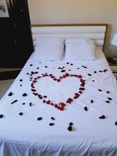 Una cama con un corazón hecho de rosas en Casafrancesbqte, en Boquete