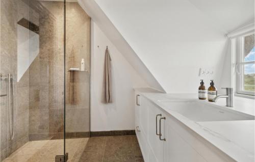 uma casa de banho branca com um chuveiro e um lavatório. em 3 Bedroom Nice Home In Fan em Sønderho