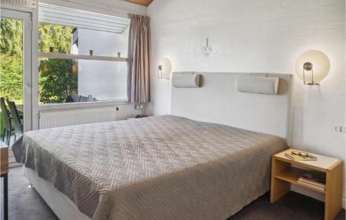 een slaapkamer met een groot bed en een raam bij 2 Bedroom Awesome Apartment In Vggerlse in Bøtø By