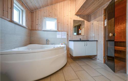 ØrbyにあるAwesome Home In Knebel With 4 Bedrooms And Saunaの木製の壁のバスルーム(白いバスタブ付)