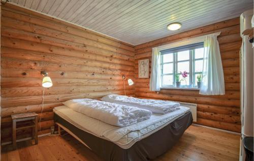 um quarto com uma cama num chalé de madeira em Gorgeous Home In Knebel With Wifi em Skødshoved Strand