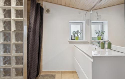 ein weißes Badezimmer mit einem Waschbecken und einem Spiegel in der Unterkunft Stunning Home In Broager With Wifi in Broager