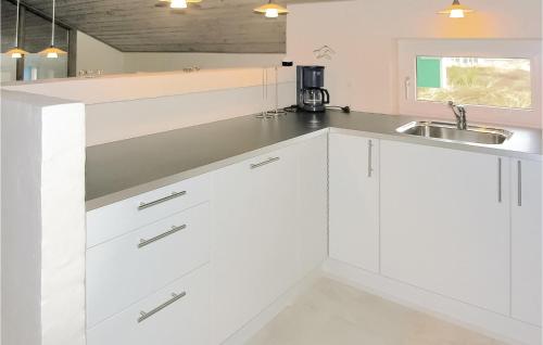クリムトラにあるAmazing Home In Thisted With Saunaの白いキャビネットとシンク付きのキッチン