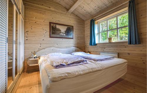 a bedroom with a bed in a room with wooden walls at Nice Home In Ebeltoft With Kitchen in Ebeltoft