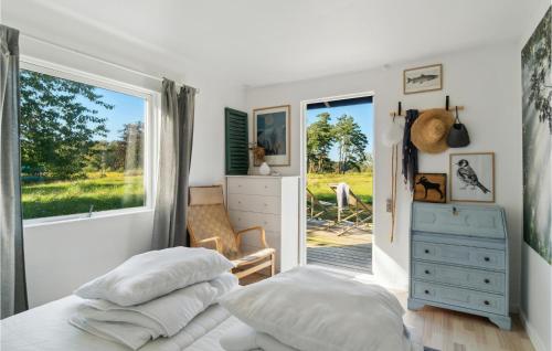 um quarto com uma cama com almofadas e uma janela em Cozy Home In Grlev With Kitchen em Gørlev