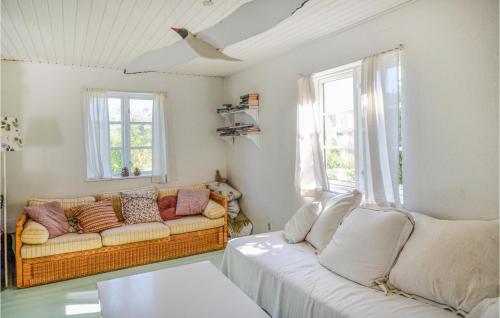 a living room with a couch and two windows at Beautiful Home In Anholt With Kitchen in Anholt