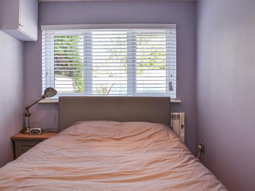 a bed in a bedroom with a large window at Mutley Hall in Eastergate
