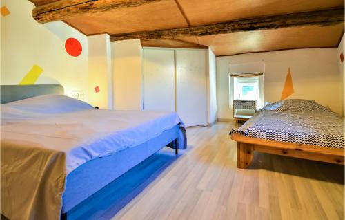 een slaapkamer met een bed en een bank erin bij Stunning Home In Laudun-lardoise With Wifi in Laudun