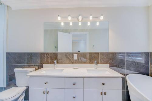 a bathroom with a sink and a toilet and a mirror at Luxury house, 25 minutes to Toronto Downtown in Toronto