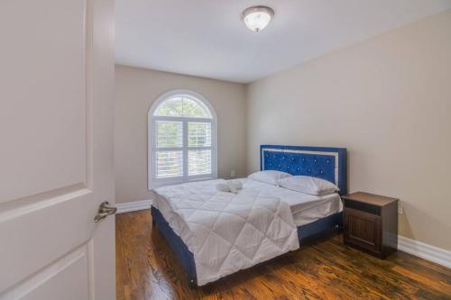 um quarto com uma cama grande e uma janela em Luxury house, 25 minutes to Toronto Downtown em Toronto