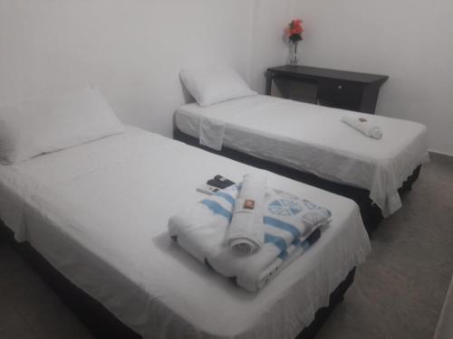 duas camas num quarto de hotel com toalhas em HOTEL HOUSE CIA em Barrancabermeja