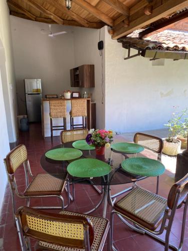 a patio with green tables and chairs and a kitchen at Casa Colonial in Suchitoto