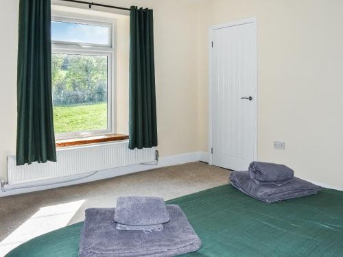 1 dormitorio con 2 camas y ventana en Woodside Cottage, en Low Etherley