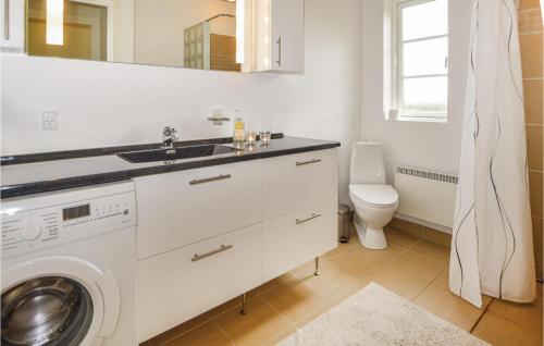 y baño con lavabo y lavadora. en 3 Bedroom Amazing Home In Juelsminde, en Sønderby