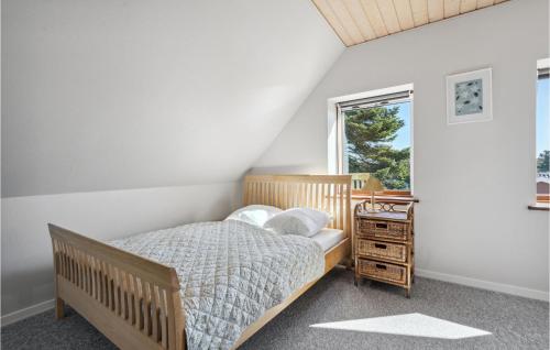 a bedroom with a wooden bed and a window at Beautiful Home In Nrre Nebel With Kitchen in Nørre Nebel
