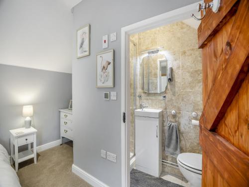 uma casa de banho com um chuveiro, um WC e um lavatório. em Huntspill Cottage em Holbeach