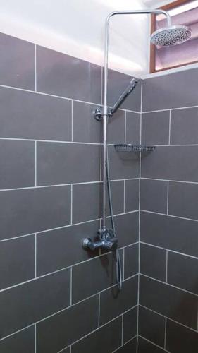 a shower in a bathroom with gray tiles at Mana - SRFB 1 in Mana