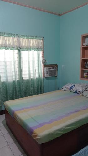 - un grand lit dans une chambre avec fenêtre dans l'établissement JVC Home (Beside Federico's Resto), à Ormoc
