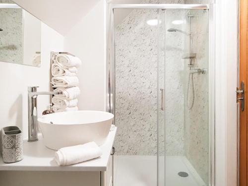a white bathroom with a shower and a sink at Palace View - Uk40569 in Falkland