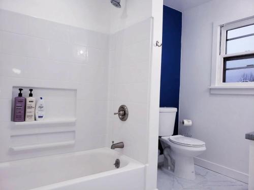 a bathroom with a white tub and a toilet at New Downtown on BSU Campus 3 Beds Fully Remodeled in Boise
