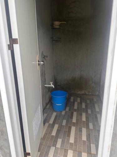 a bathroom with a blue bucket in a room at Gratum Beach Resort in Dapitan