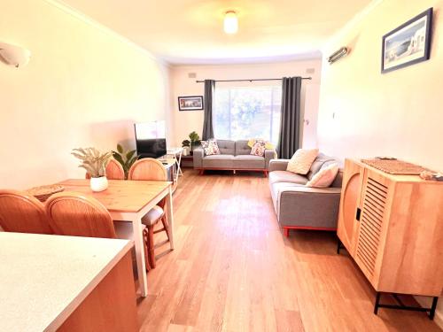a living room with a couch and a table at Victor Seaside Villa in Victor Harbor