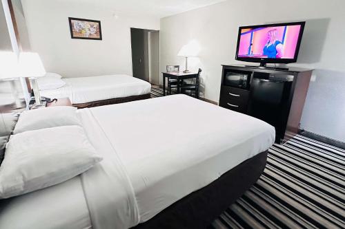 a hotel room with two beds and a flat screen tv at Econo Lodge in Ardmore