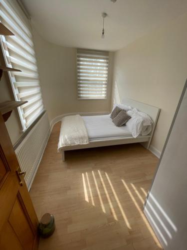 a bedroom with a bed in a room with a window at Entire 3 BR Home - Minutes to Emirates Stadium! in London