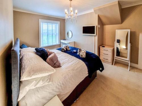 Un dormitorio con una cama grande y una lámpara de araña. en Jacks House- Uk40741 en Tywyn