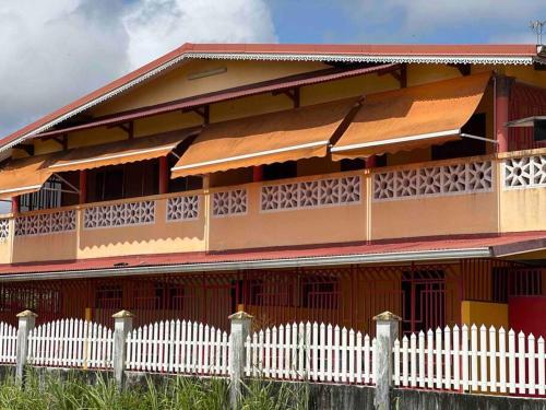 a red building with a white fence in front of it at Mana - SRFB 3 in Mana